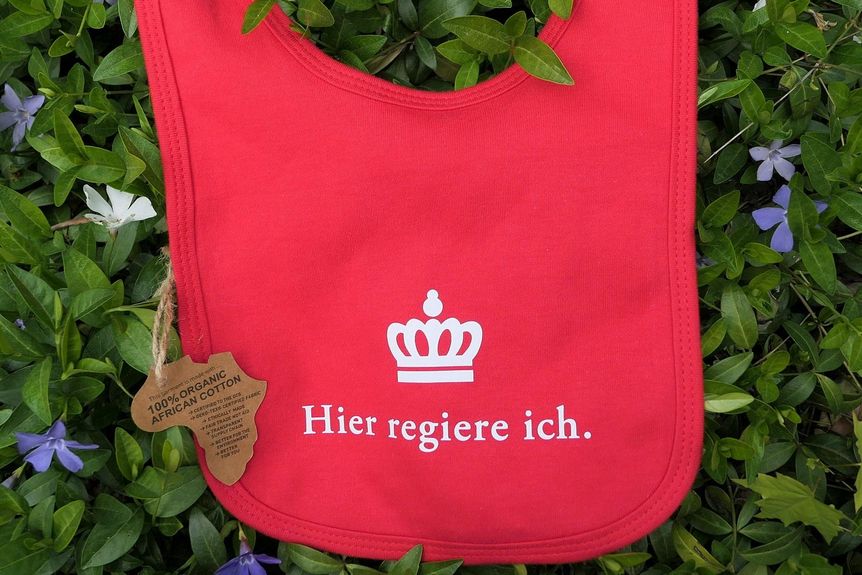 Schloss Bruchsal, Babylätzchen für Prinzessinnen und Prinzen in rot. 