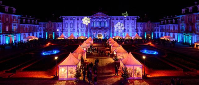 Schloss Bruchsal, Adventsmarkt im Ehrenhof bei Nacht mit beleuchteter Schlossfassade